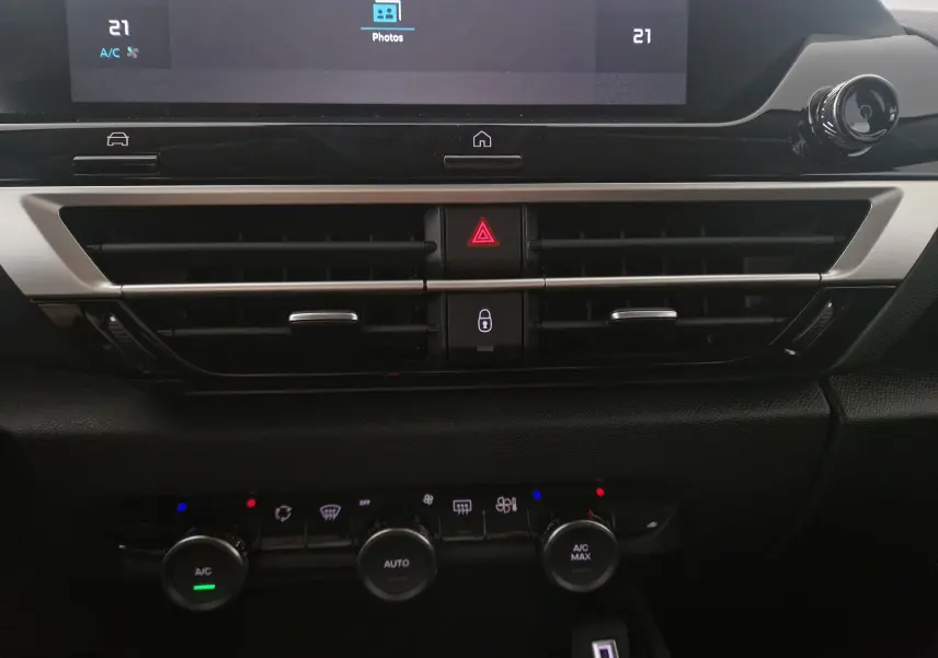 Détail du tableau de bord de la Citroën C4 blanc Okenite 2025, avec commandes climatisation et écran tactile visible.