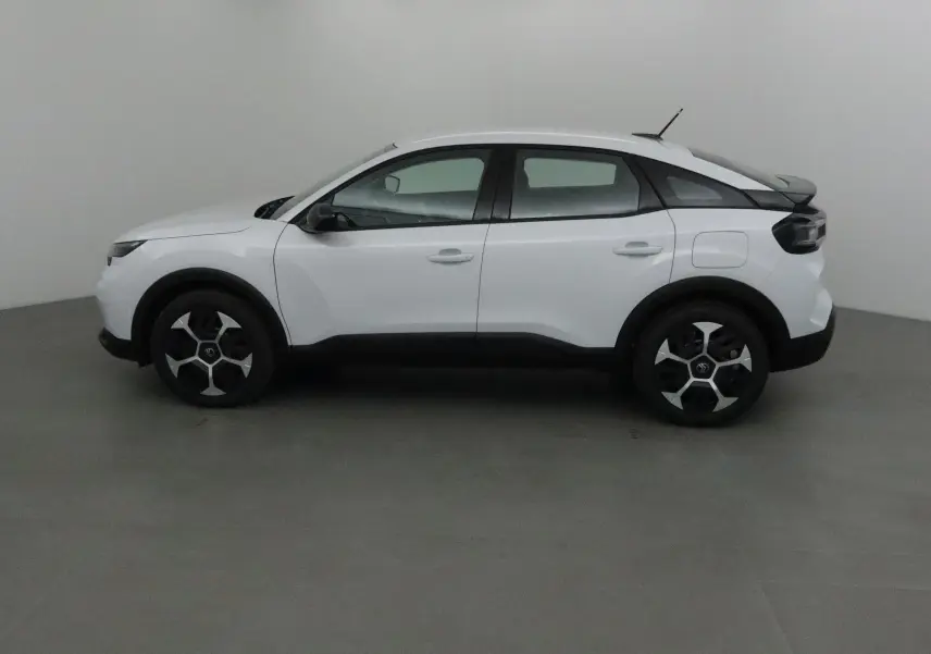 Profil côté gauche d'une Citroën C4 blanc Okenite 2025 avec jantes noires et détails noirs contrastants.