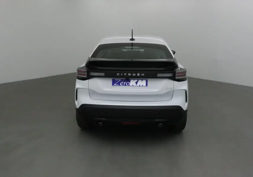 Vue arrière d'une Citroën C4 blanche Okenite avec bande noire et feux arrière horizontaux dans un studio.