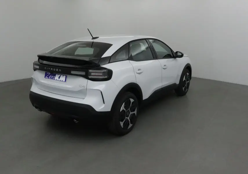 Citroën C4 blanc Okenite vue 3/4 arrière droit, avec toit noir contrastant et jantes stylisées noires et argentées.