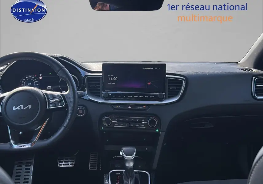 Vue intérieure frontale du tableau de bord noir du KIA Xceed 2024 avec écran tactile et volant multifonction cuir.