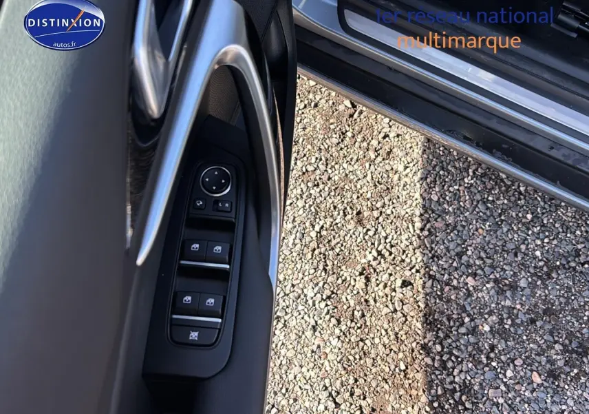 Détail des commandes des vitres et rétroviseurs sur la porte avant gauche d'un KIA Xceed gris 2024.