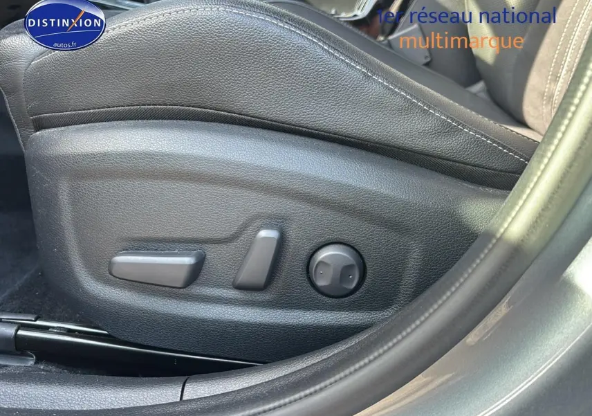 Détail des commandes électriques du siège conducteur noir sur KIA Xceed gris, vue latérale côté gauche.