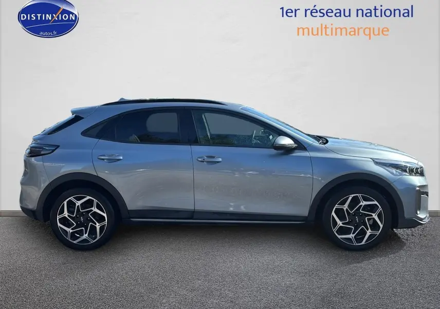 Profil droit d'un KIA Xceed gris 2024 avec jantes alu au design géométrique et vitres arrière surteintées.