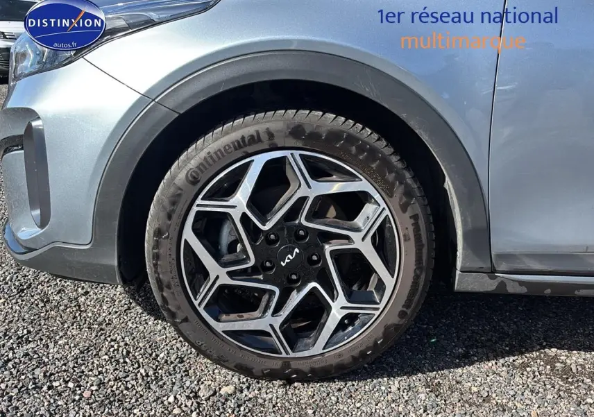 Gros plan sur la roue avant gauche avec jante alu noire et argentée d’une KIA Xceed gris métallisé.