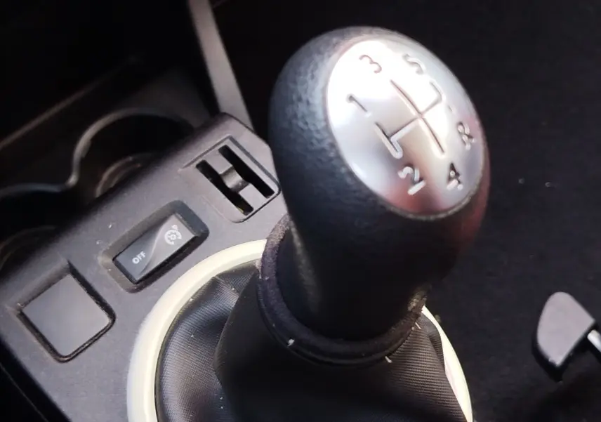 Gros plan sur le levier de vitesses manuel noir avec marquages argentés dans une Renault Twingo Blanc Cristal de 2016.