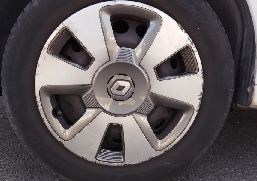 Gros plan sur la roue avant droite d'une Renault Twingo blanche, avec jante en alliage argentée et logo Renault central.