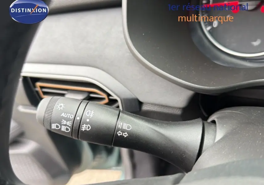 Gros plan sur la commande des phares et clignotants du tableau de bord intérieur du Dacia Jogger vert cèdre métal.