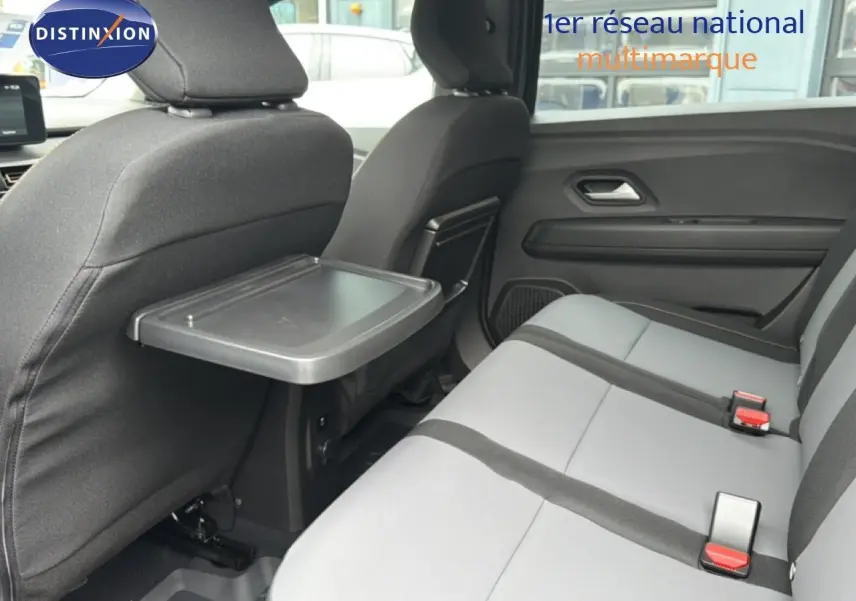 Vue intérieure côté droit des sièges arrière gris clair avec tablette rabattable sur un Dacia Jogger vert cèdre métal 2026.