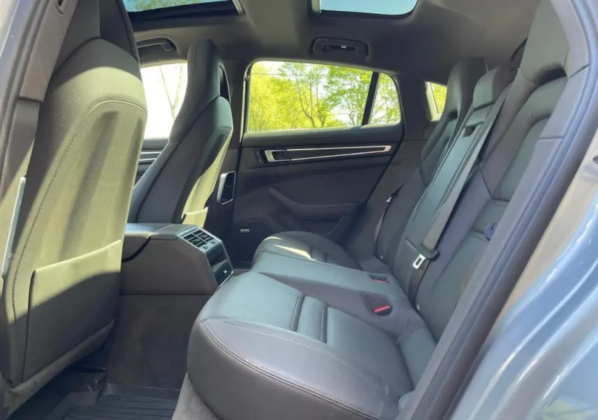 Vue intérieure arrière côté droit de la Porsche Panamera 4 V6 3.0 Hybrid gris, sièges cuir et toit panoramique ouverts.