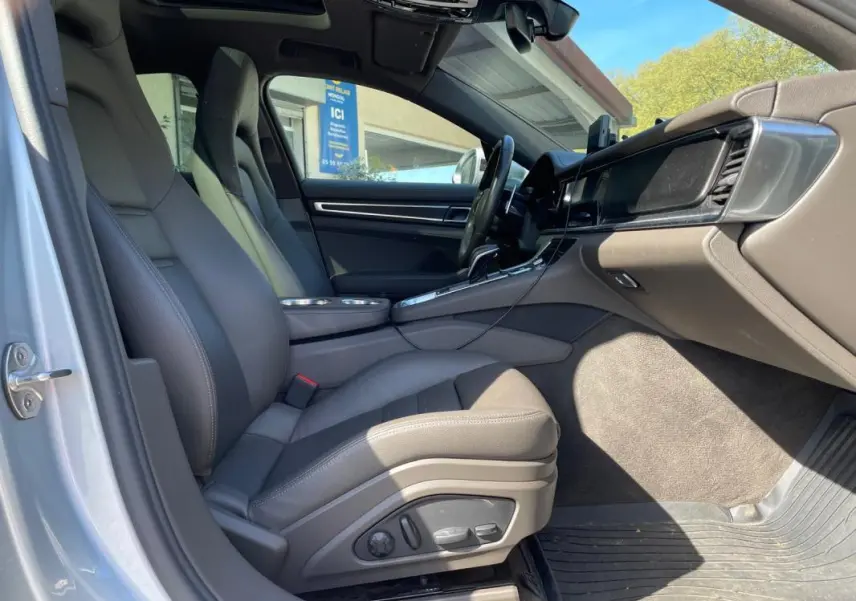 Vue intérieure côté conducteur de la Porsche Panamera 4 V6 Hybrid 2022 avec sièges gris et tableau de bord moderne.