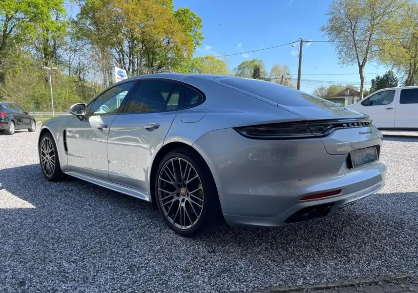 Vue 3/4 arrière droite d'une Porsche Panamera 4 V6 3.0 Hybrid gris métallisé avec jantes noires distinctives.