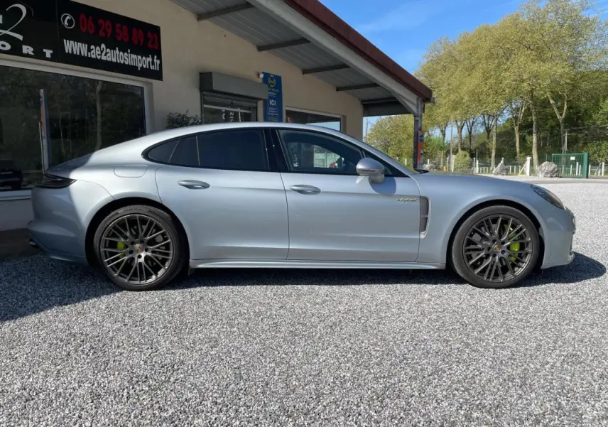 Vue de profil côté gauche d'une Porsche Panamera 4 V6 3.0 Hybrid gris métallisé avec jantes noires et étriers verts.