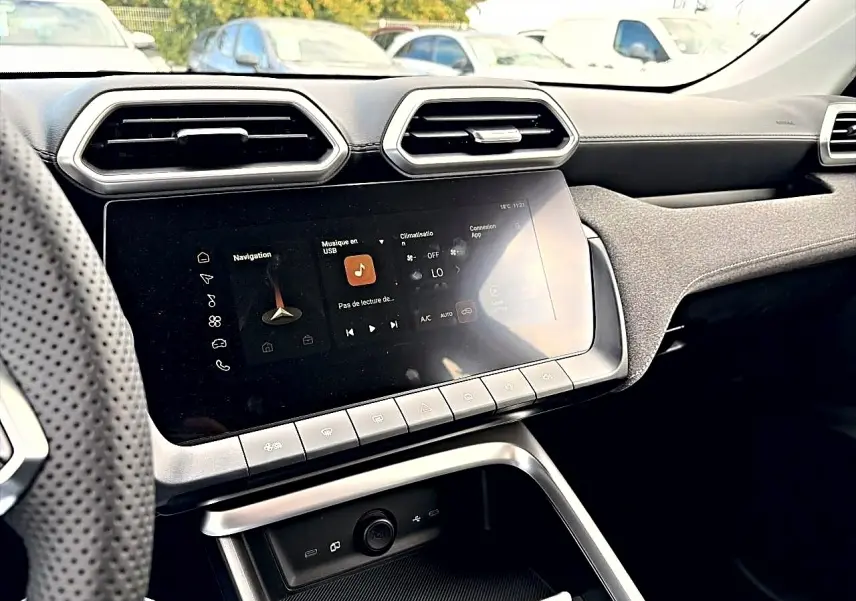 Vue intérieure du tableau de bord du MG ZS 1.5 hybrid 197, avec écran tactile et aérateurs hexagonaux.
