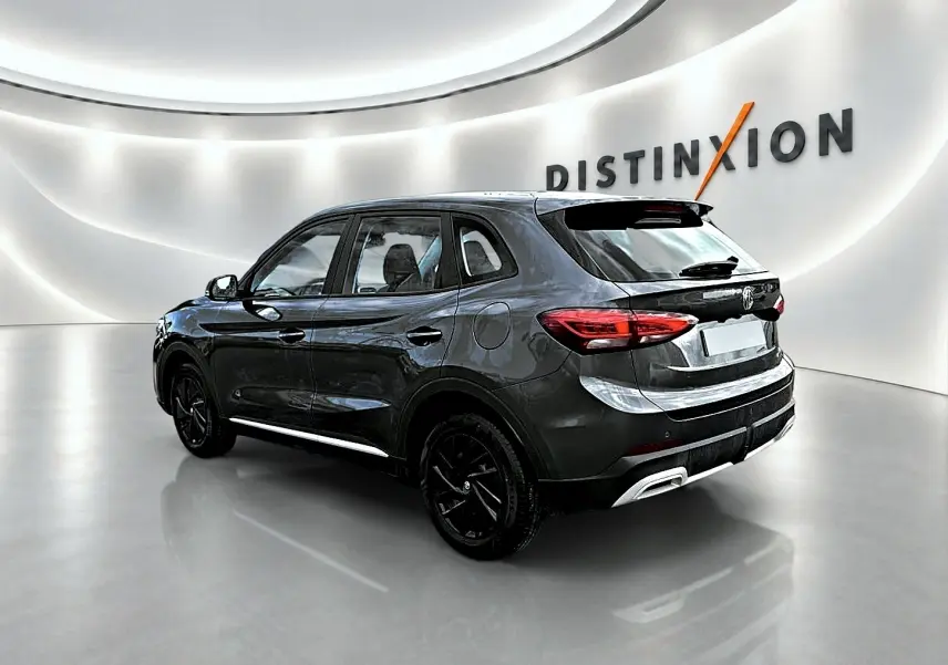 Vue 3/4 arrière droite du MG ZS Camden grey 2026 hybride, avec jantes noires et becquet arrière distinctif.