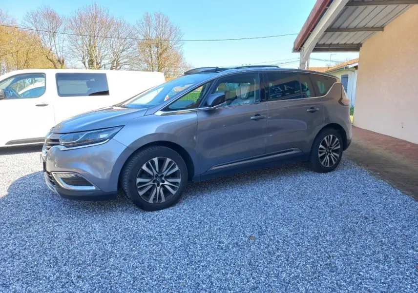 Renault Espace gris métallisé vu de profil côté gauche, avec jantes alliage et toit panoramique visible.