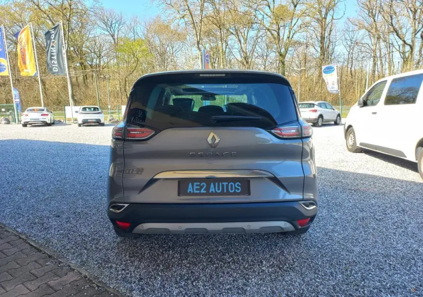 Vue arrière du Renault Espace gris 2017, mettant en valeur ses feux distinctifs et son logo central sur un parking extérieur.