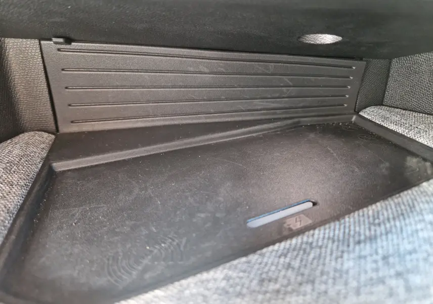 Gros plan sur le chargeur sans fil intégré au tableau de bord du Peugeot 3008 gris titane 2026.