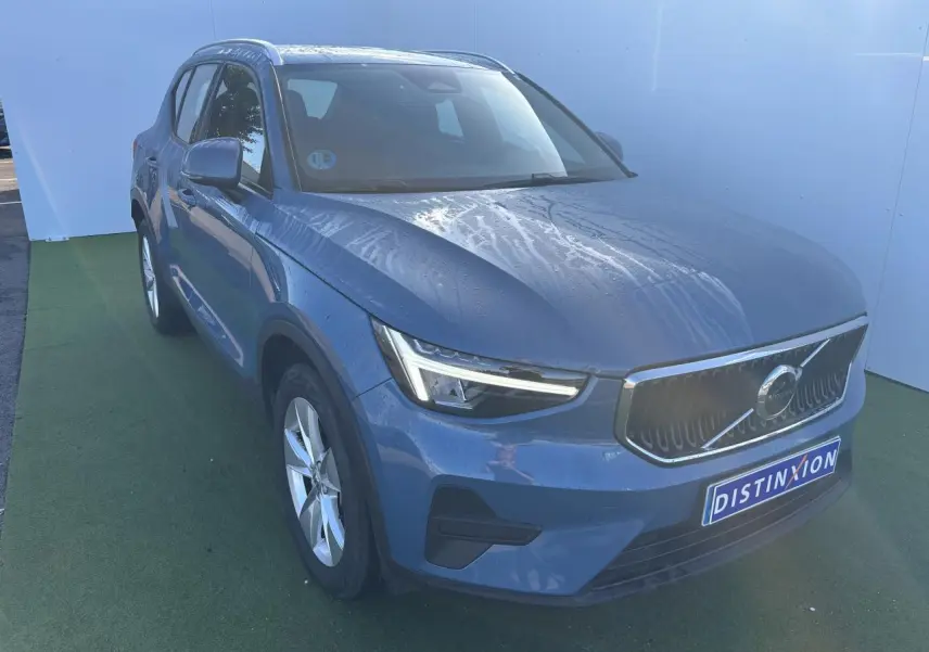 Volvo XC40 Fjord Blue métal vue 3/4 avant avec calandre chromée et feux LED en forme de marteau.