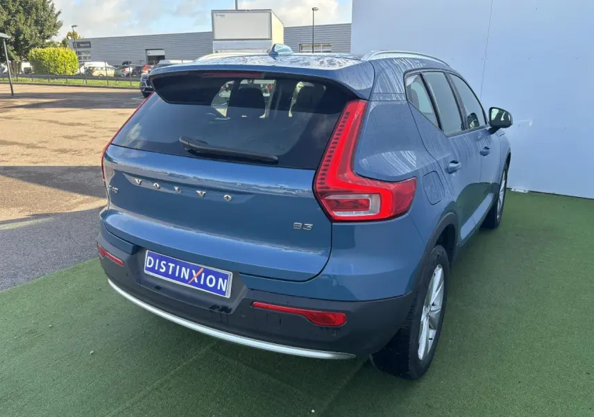 Vue 3/4 arrière droite d'un Volvo XC40 Fjord Blue avec feux arrière en L et jantes alliage 18 pouces.