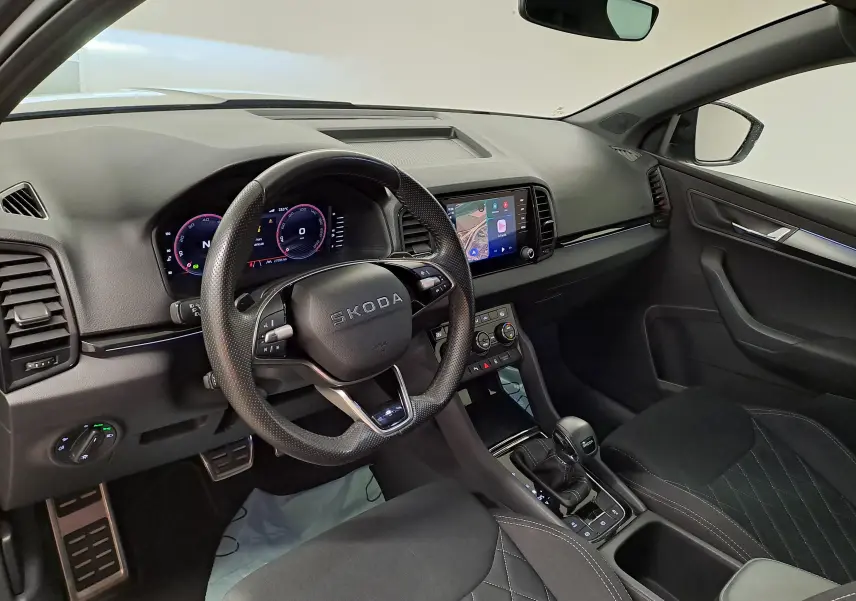 Vue intérieure côté conducteur du Skoda Karoq 2025 gris graphite, avec tableau de bord numérique et console centrale moderne.
