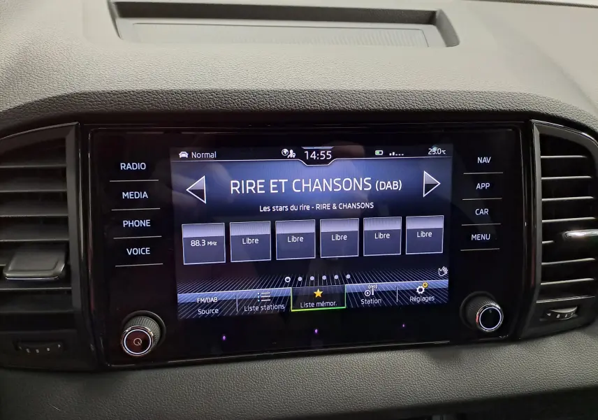 Tableau de bord du Skoda Karoq 2025 avec écran tactile central affichant la radio DAB sur fond noir.