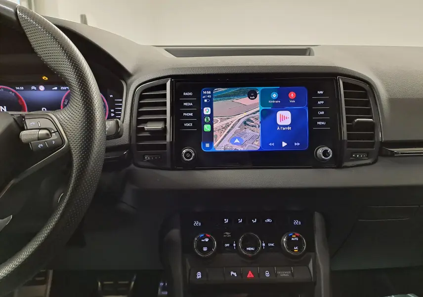 Vue intérieure du tableau de bord du Skoda Karoq 2025 avec écran tactile central affichant la navigation et commandes climatisation.