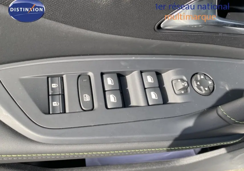 Gros plan sur les commandes de lève-vitres et rétroviseurs côté gauche intérieur d’une Peugeot 308 Hybrid blanche.