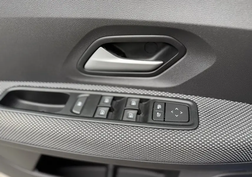 Gros plan sur la poignée intérieure et les commandes des vitres côté conducteur de la Dacia Sandero Stepway 2025, finition Expression.