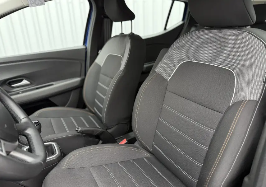 Vue intérieure rapprochée des sièges avant gris avec surpiqûres contrastantes de la Dacia Sandero Stepway Bleu Iron.