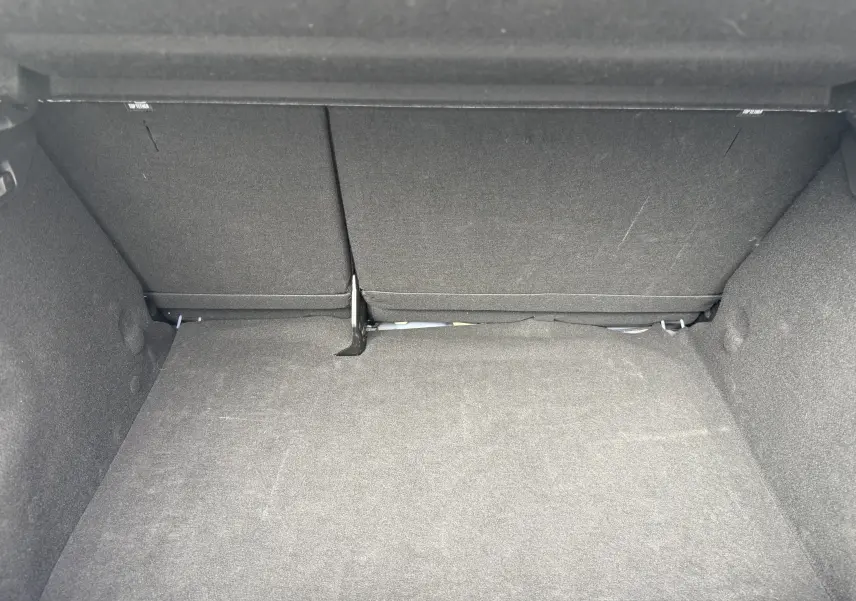 Coffre spacieux et vide de la Dacia Sandero Stepway 2025, vue intérieure arrière avec revêtement gris foncé.