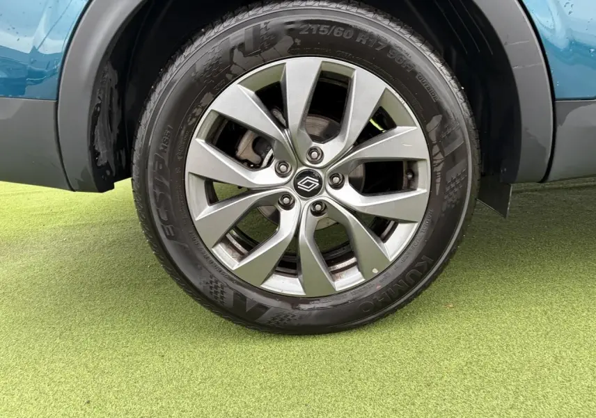 Gros plan sur la roue avant droite avec jante alliage grise 17 pouces du Renault Arkana Bleu Zanzibar.