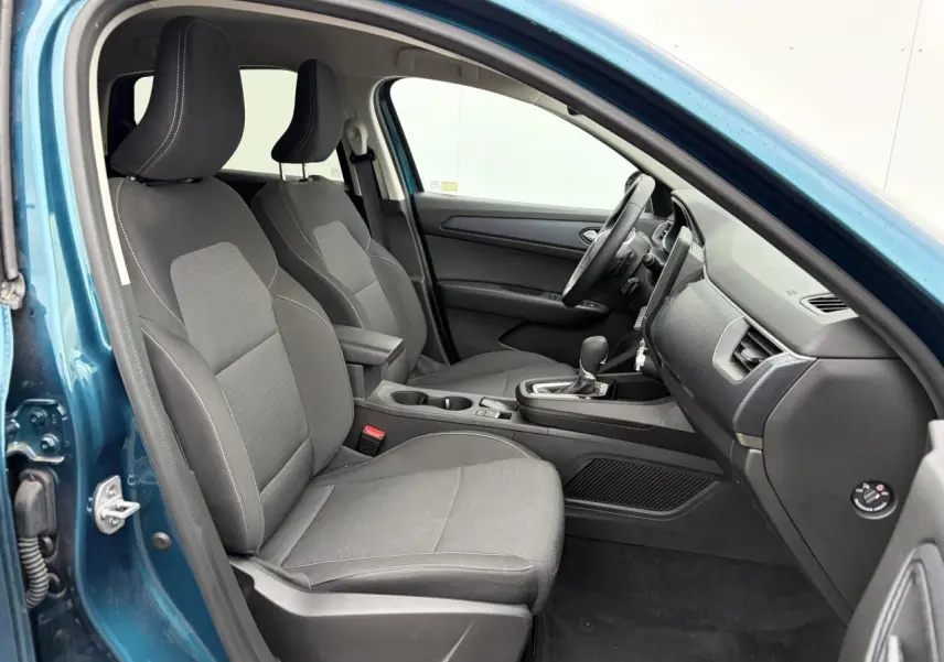 Vue intérieure côté conducteur de la Renault Arkana bleu Zanzibar, montrant les sièges avant et la console centrale.