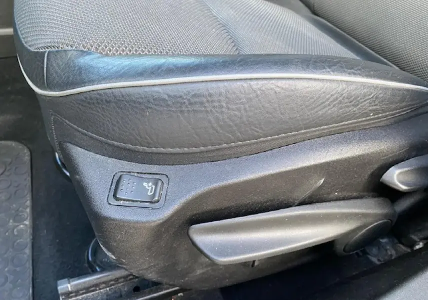 Gros plan sur le côté gauche du siège conducteur en cuir noir du Fiat 500X Cross 2016, avec réglage manuel et bouton de chauffage.