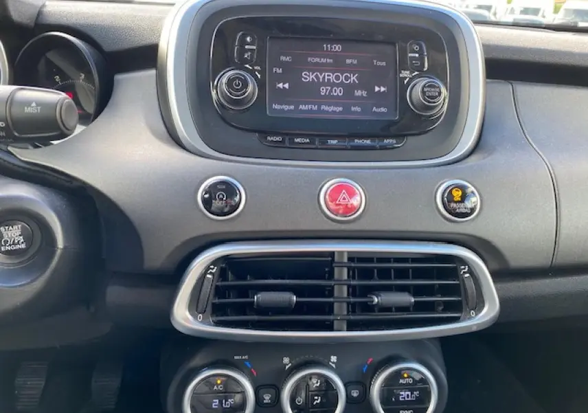 Tableau de bord intérieur du Fiat 500X Cross 2016 noir, avec écran central et commandes climatisation visibles.