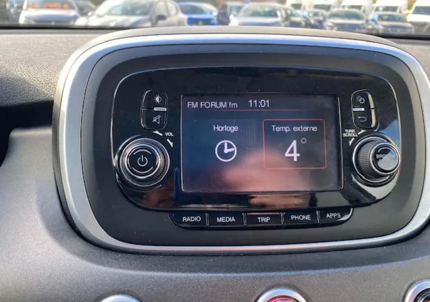 Écran central tactile de la console d'une Fiat 500X Cross 2016, affichant l'heure et la température extérieure.