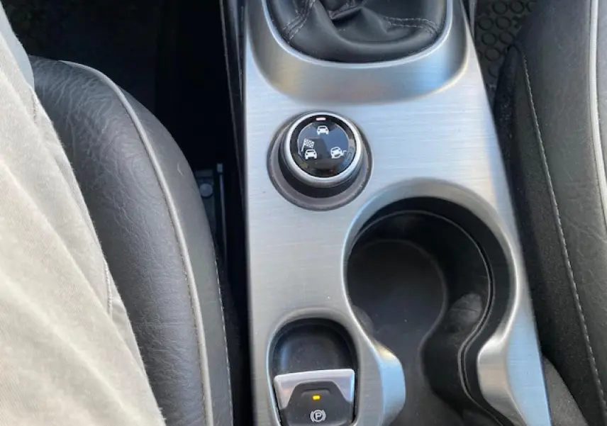 Vue rapprochée de la console centrale du Fiat 500X noir 2016, avec sélecteur de modes de conduite et frein à main électrique.