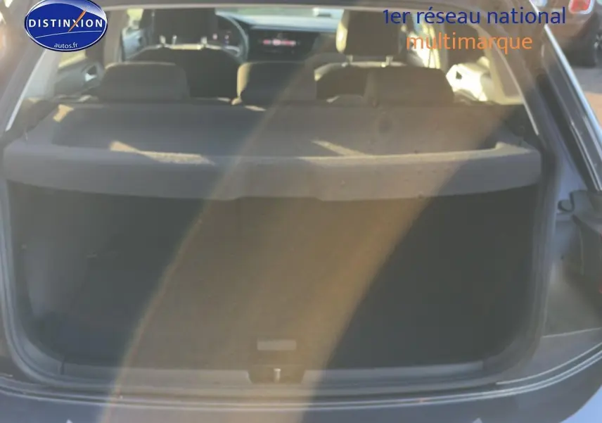 Vue arrière du coffre ouvert d'une Volkswagen Polo gris 2025, montrant l'intérieur et la tablette cache-bagages.