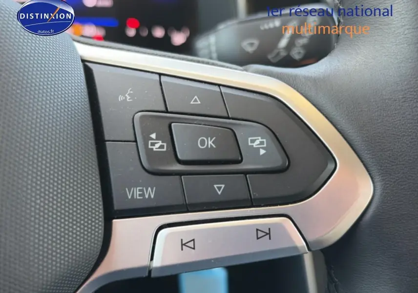 Gros plan sur les commandes multifonctions du volant cuir d'une Volkswagen Polo gris 2025, côté gauche.