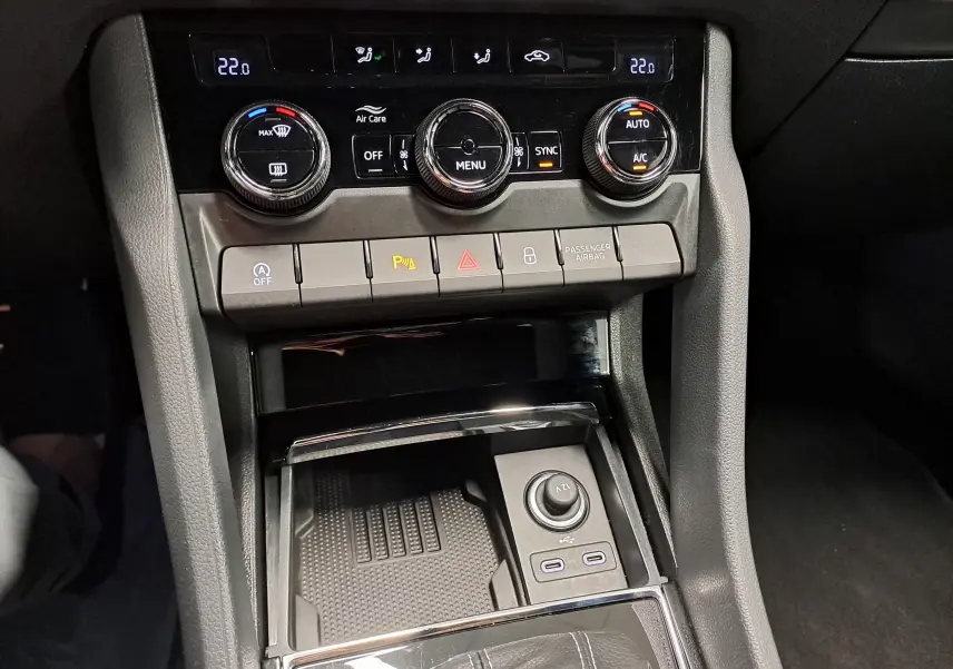 Vue rapprochée de la console centrale du Skoda Karoq 2.0 TDI 150 DSG7 Sportline avec commandes climatisation et ports USB.