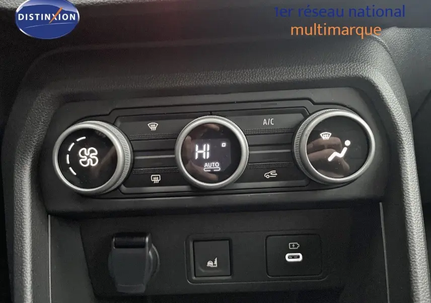 Vue rapprochée du tableau de bord du Dacia Jogger 2026, montrant les commandes de climatisation et prises USB en plastique noir.
