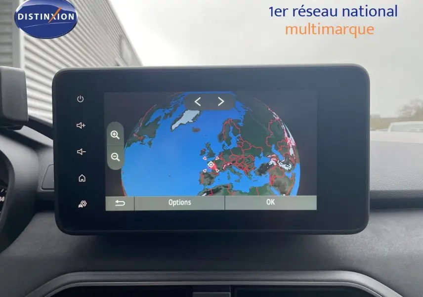 Écran central tactile du tableau de bord du Dacia Jogger gris, affichant une carte du globe en mode navigation.