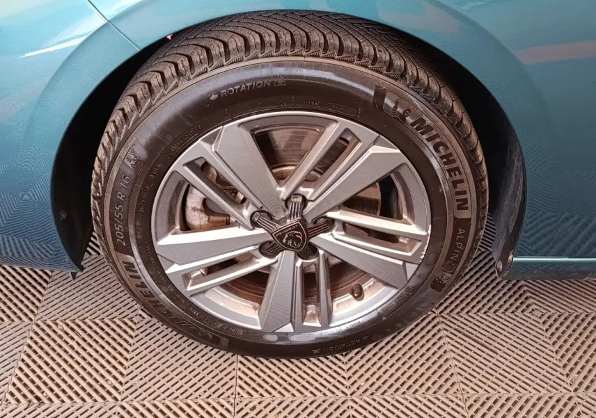 Gros plan sur la roue avant gauche d’une Peugeot 308 2023 bleue avec jante alliage et pneu Michelin.