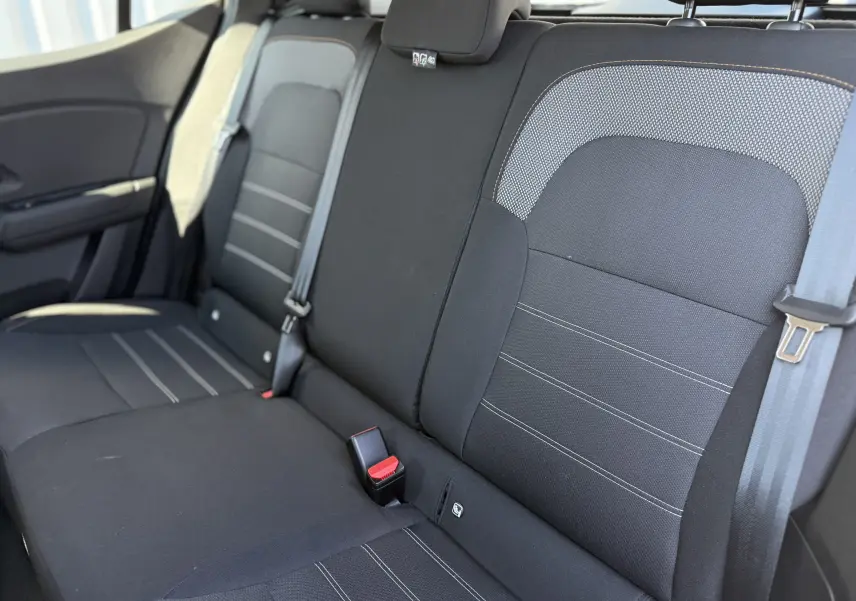 Vue intérieure montrant la banquette arrière noire avec surpiqûres grises du Dacia Sandero Stepway 2025.