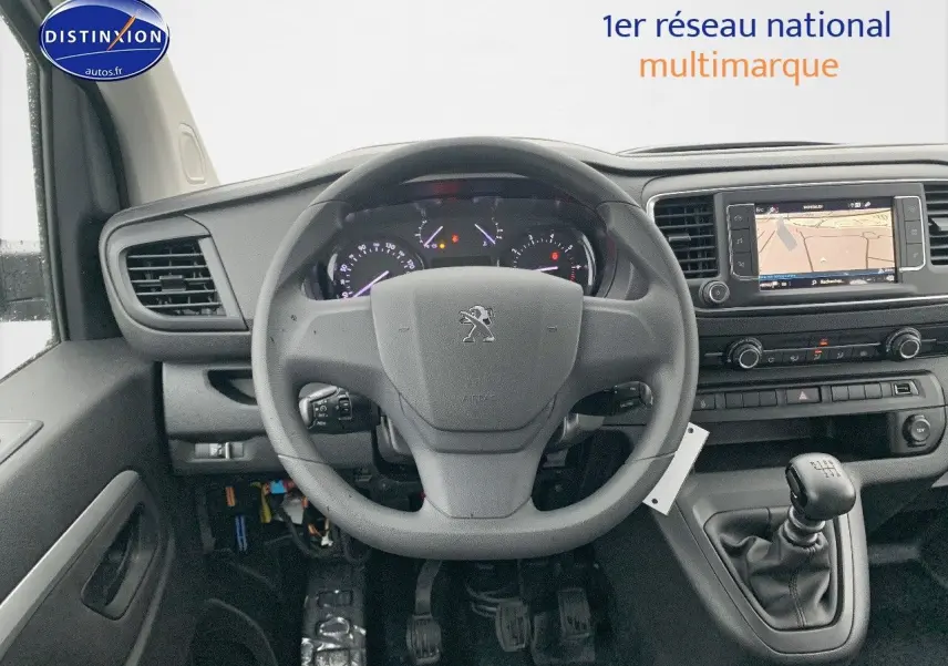 Vue intérieure frontale du tableau de bord et volant du Peugeot Expert Long blanc avec boîte manuelle et écran de navigation intégré.