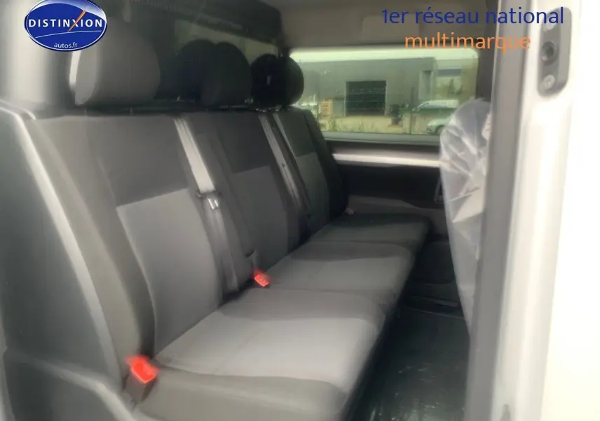 Vue latérale intérieure du Peugeot Expert Long 2023 montrant la banquette arrière en tissu gris et noir.