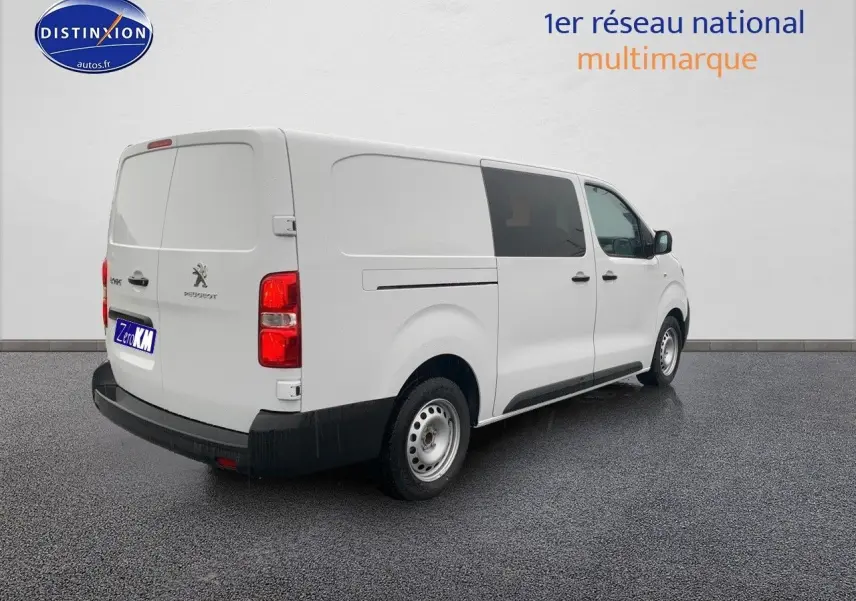 Vue 3/4 arrière droite d'un Peugeot Expert blanc 2023, fourgon long avec vitres teintées et jantes acier simples.