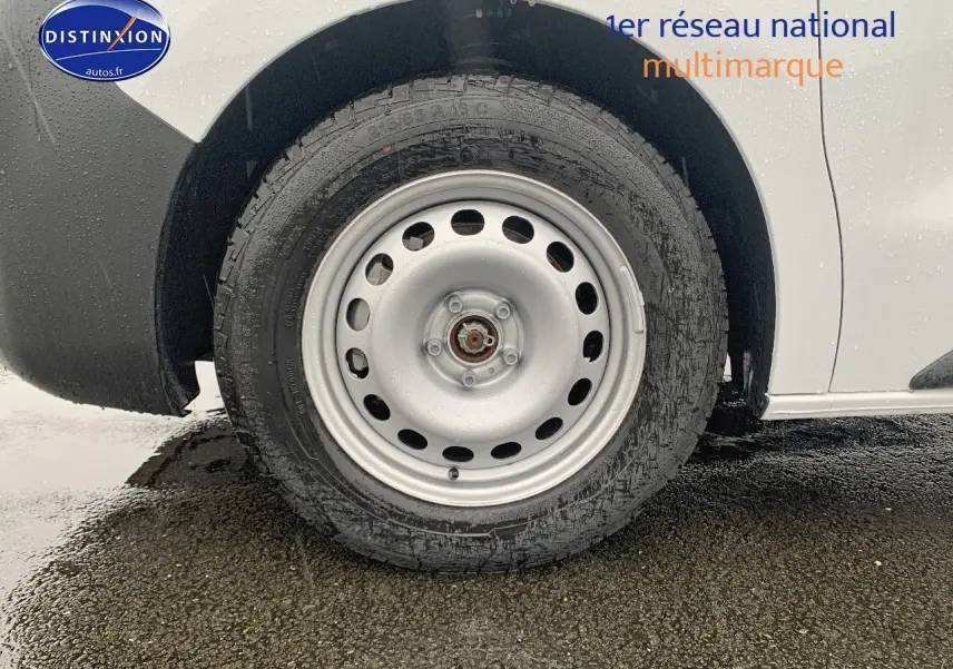 Gros plan sur la roue arrière droite en acier d'un Peugeot Expert Cabine Approfondie blanc sous la pluie.