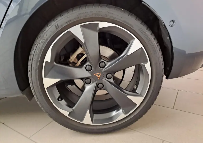 Gros plan sur la jante noire et argentée avec logo CUPRA d'une Leon 1.5 eTSI gris magnétique 2023, côté arrière droit.