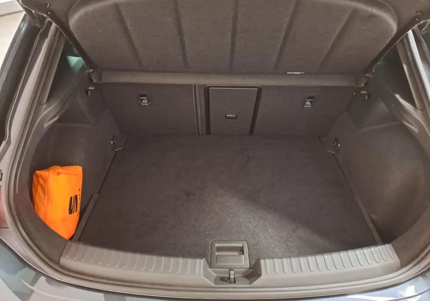 Coffre ouvert d'une CUPRA Leon 2023 gris magnétique, montrant un espace de rangement propre avec un kit de sécurité orange.